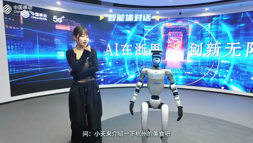 工作人员在展厅内与人形机器人进行语音互动